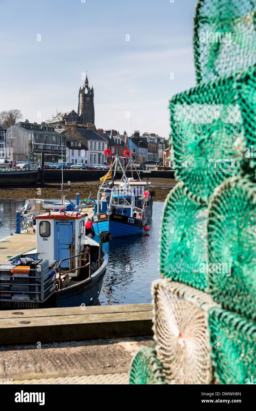 A view from some lobster creels through Tarbert harbour (Argyll and Bute, Scotland) and onto the town and Tarbert Church. Stock Photo