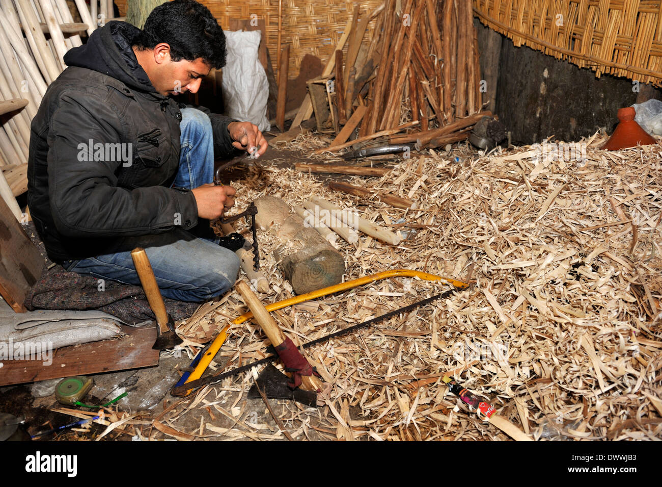 Woodworker in Marrakech workshop drilling hole in wood for chair part Stock Photo