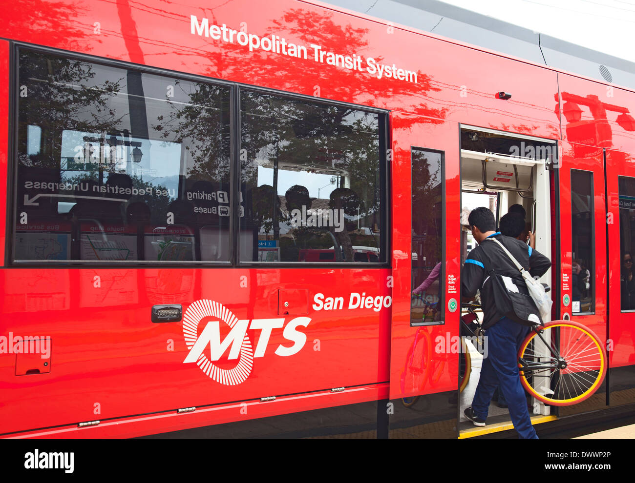 Passenger entering San Diego Trolley with a bicycle. The Red Trolley is