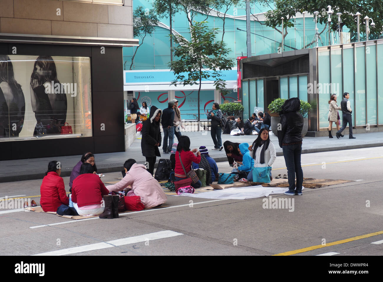 Filipino housemaids picnicking on the streets of Hong Kong Island on their day off on Sunday. Stock Photo