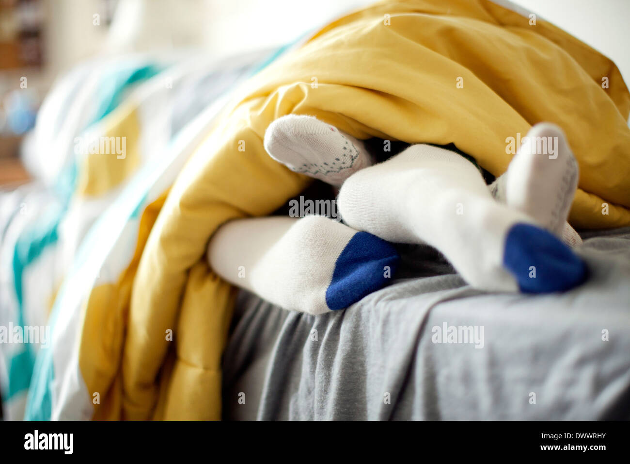 Feet of young couple lying in bed Stock Photo