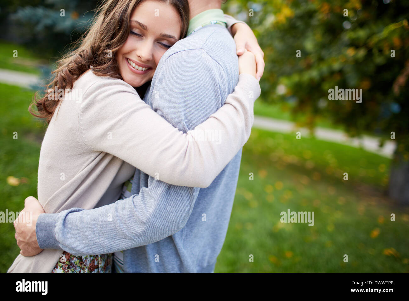 Happy girl embracing her boyfriend in park Stock Photo - Alamy