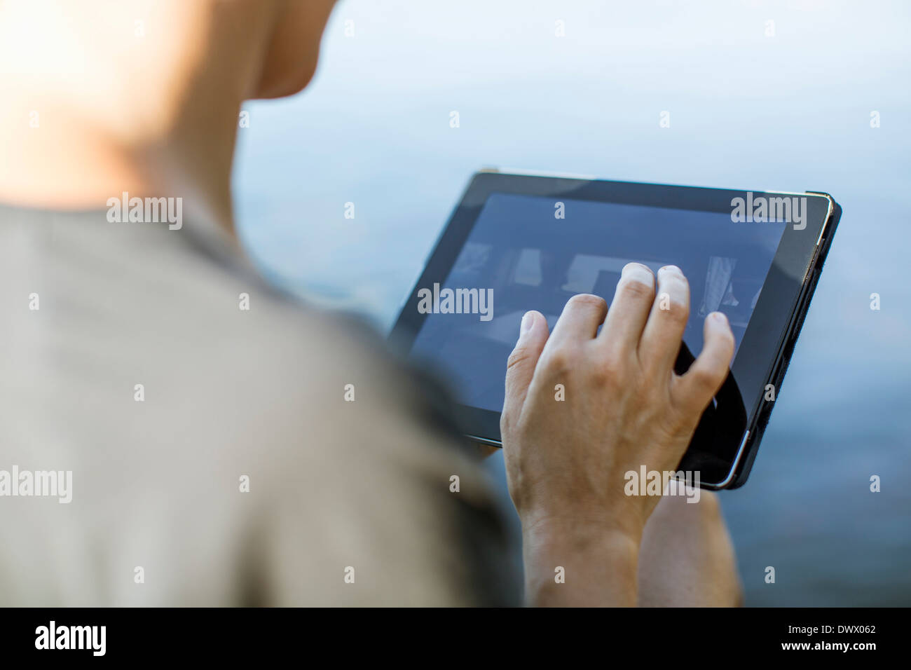 Cropped image of woman touching digital tablet outdoors Stock Photo