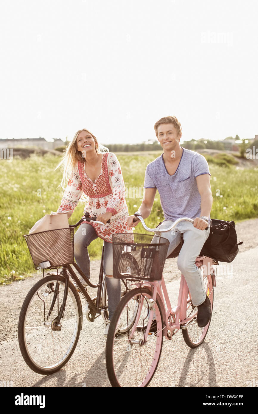 Portrait of young couple cycling on country road Stock Photo
