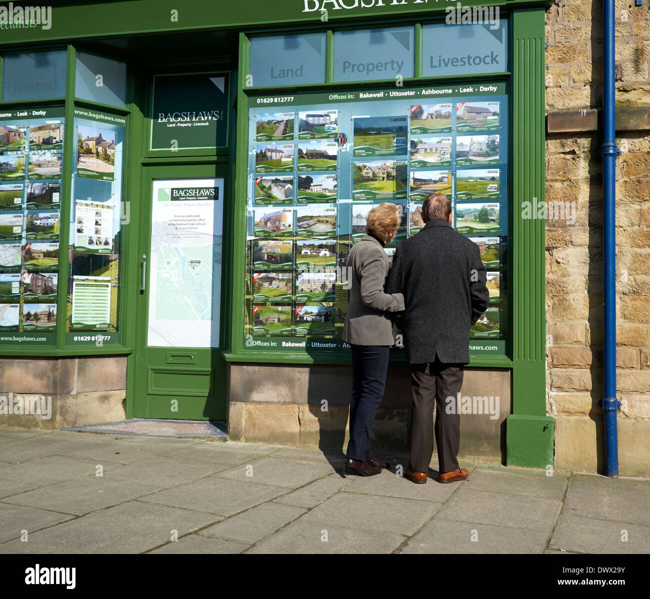 A middle aged couple looking at an estate agents window bakewell