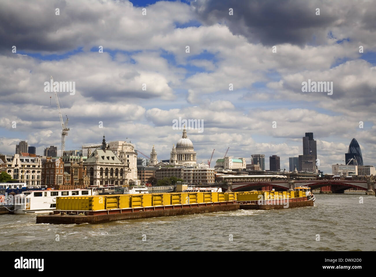 View of a barge pulling containers on the River Thames withthe City of London behind. Taken in 2006 Stock Photo