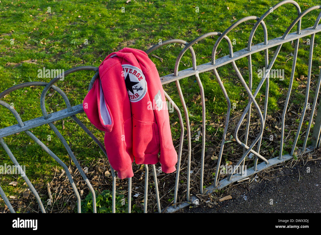 lost red sweatshirt,hoodie, on fence Stock Photo