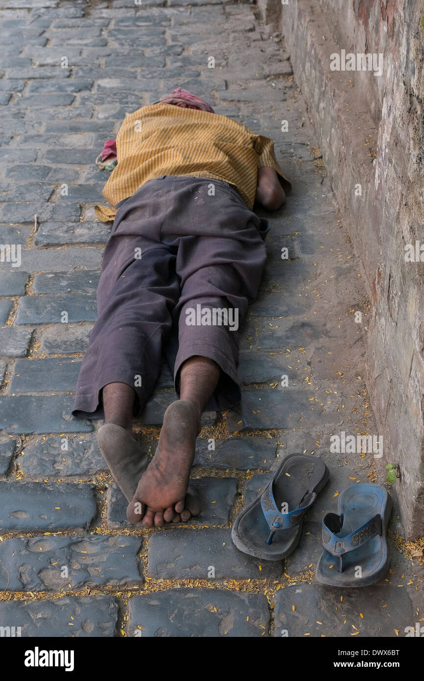 India, West Bengal, Kolkata, homeless man asleep on side of road Stock Photo