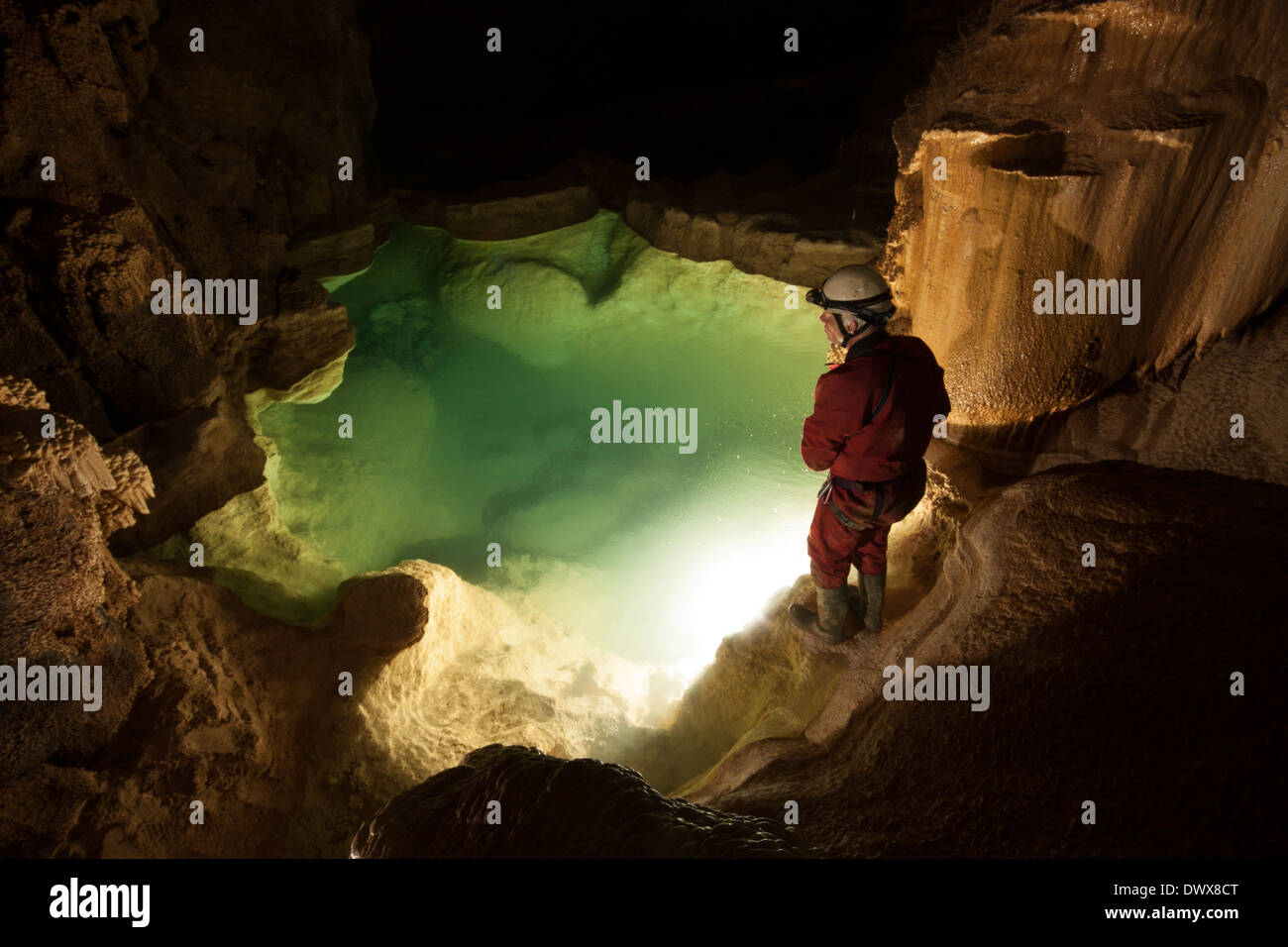 A caver illuminates a large gour pool in Cueva Coventosa, Cantabria, northern Spain, with a giant flashbulb Stock Photo