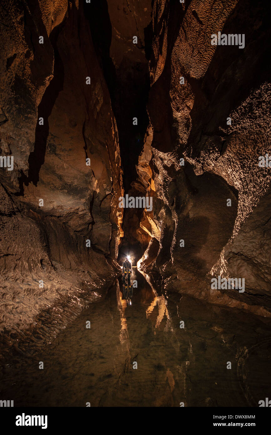 A caver in the river passage of Cueva Coventosa, Cantabria, northern Spain Stock Photo