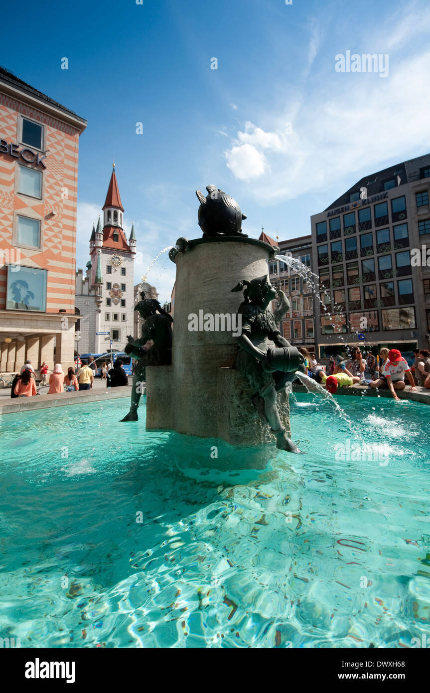 Germany, Bavaria, Munich, Marienplatz Square, Fischbrunnen Fish Fountain background Tower of the Toy Museum Stock Photo