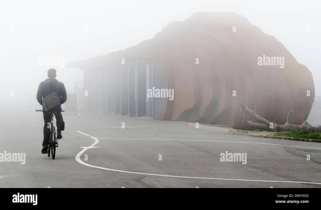 A cyclist cycling along the promenade in the fog. Stock Photo