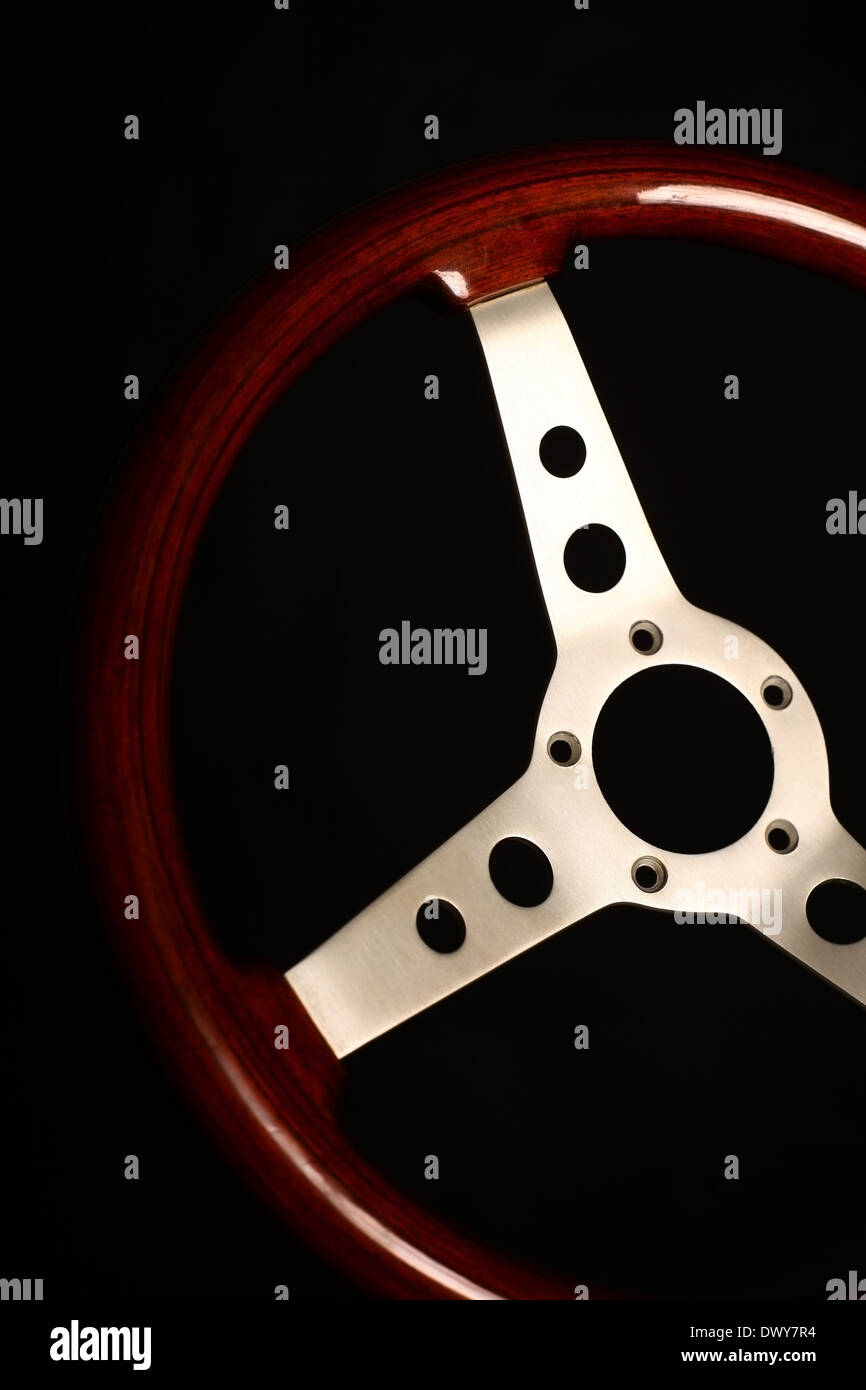 Detail of a wooden vintage steering wheel on black Stock Photo - Alamy