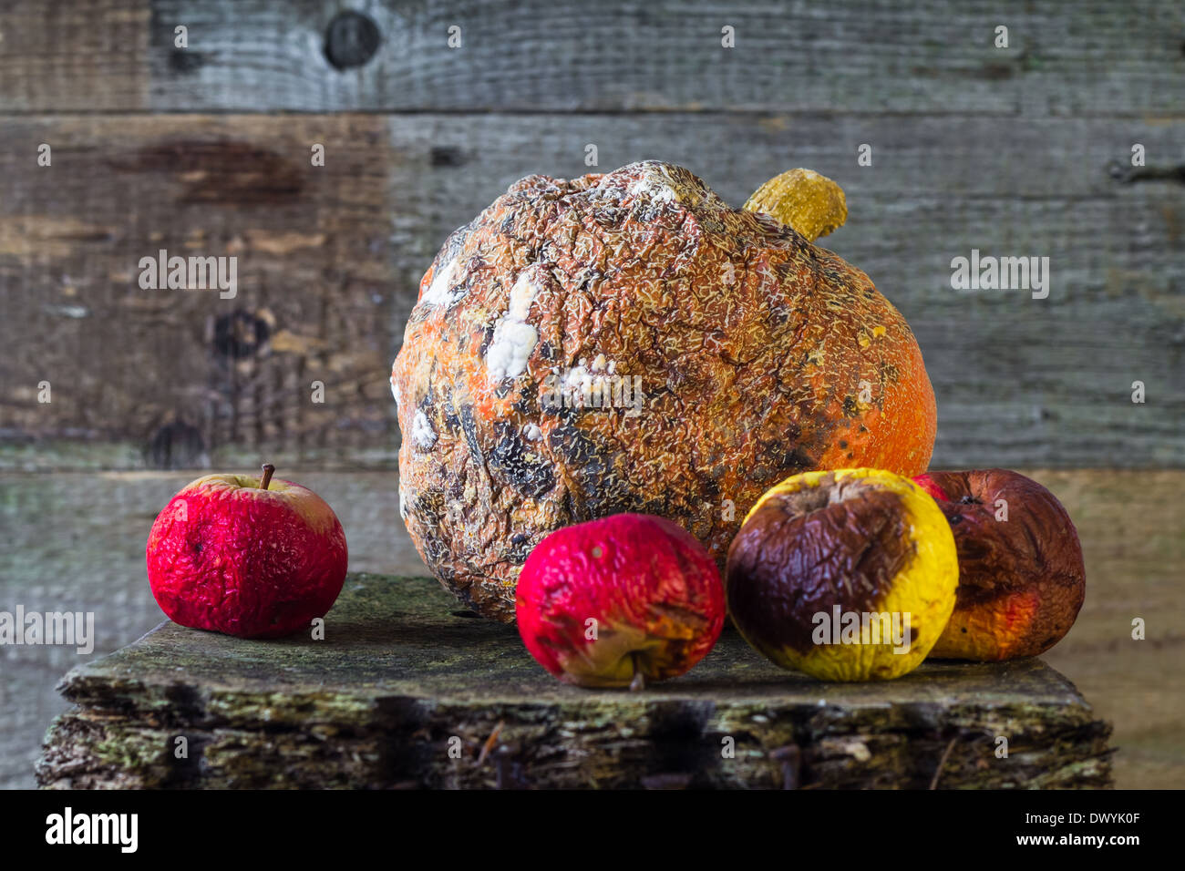 Old and rotten fruit on wooden board Stock Photo