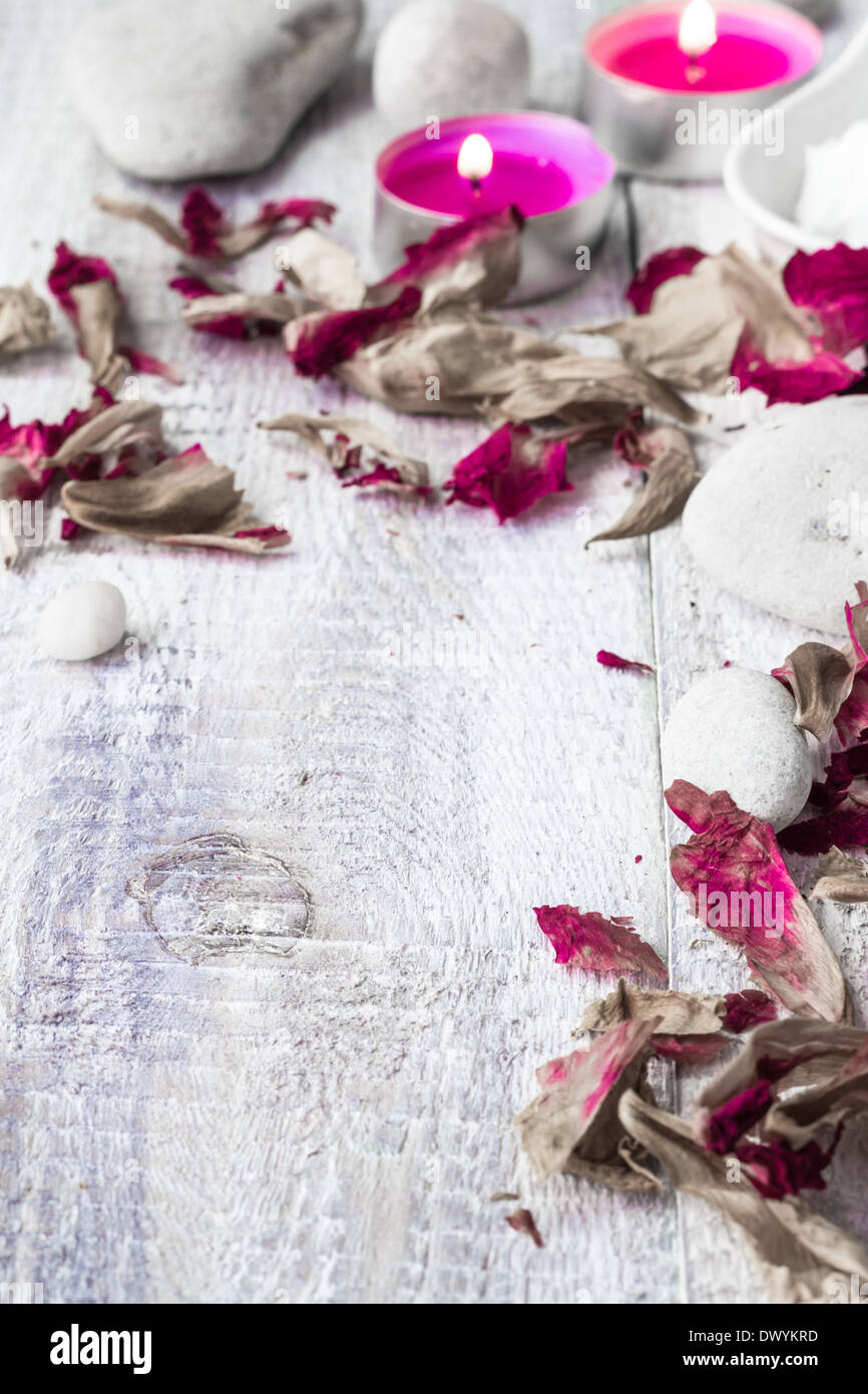 Stones, candles and petals of the rose on wooden background Stock Photo