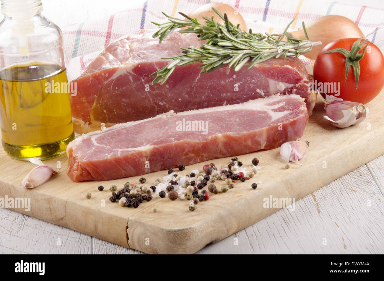 smoked back bacon joint with tomato, garlic, onion, oil and rosemary on