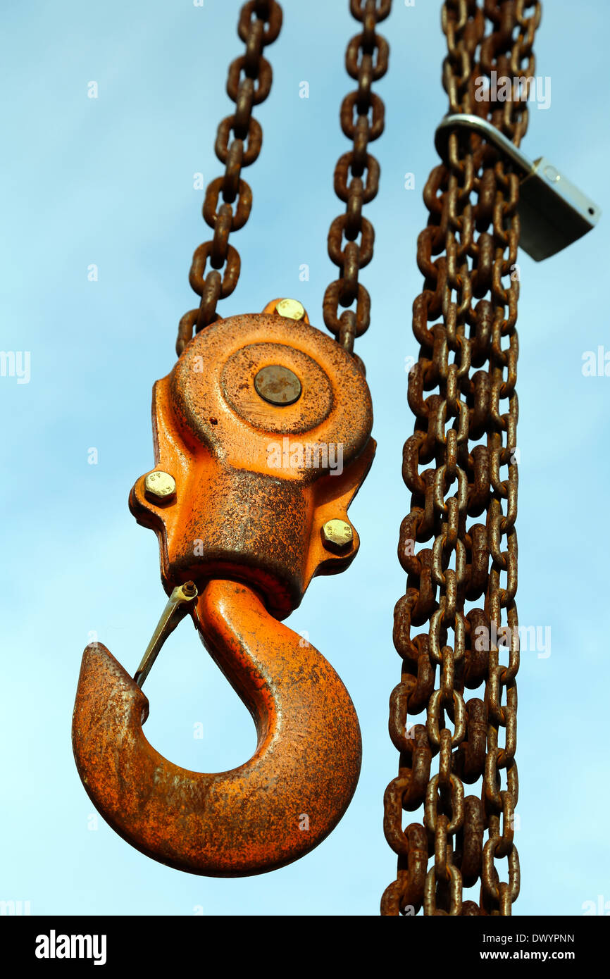 Lifting hook and metal chains with blue sky background Stock Photo