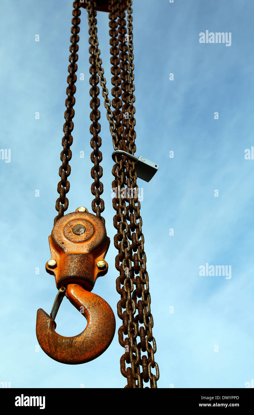 Lifting hook and metal chains with blue sky background Stock Photo