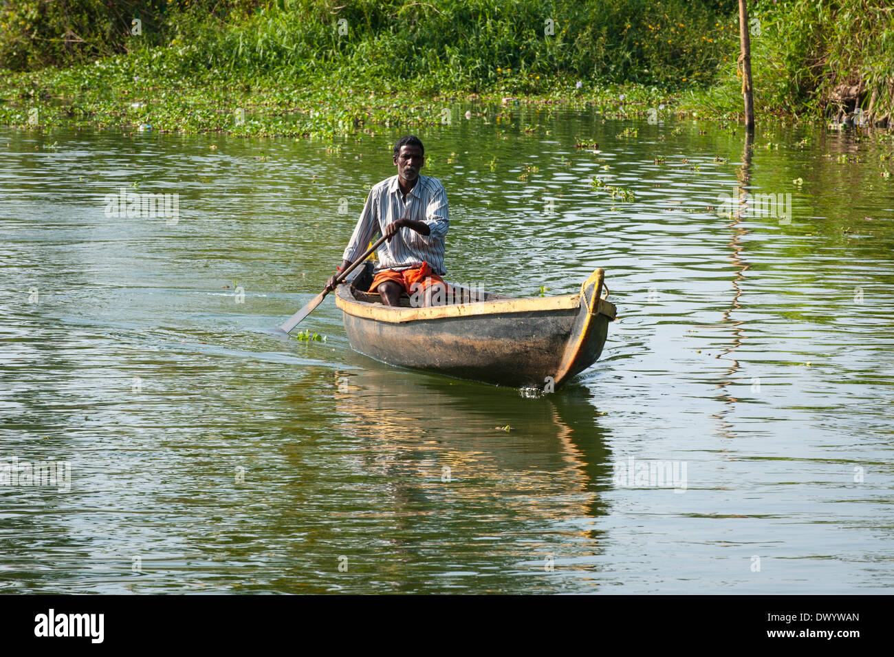 South Southern India Kerala backwater tour cruise waterway water canal man canoing paddling