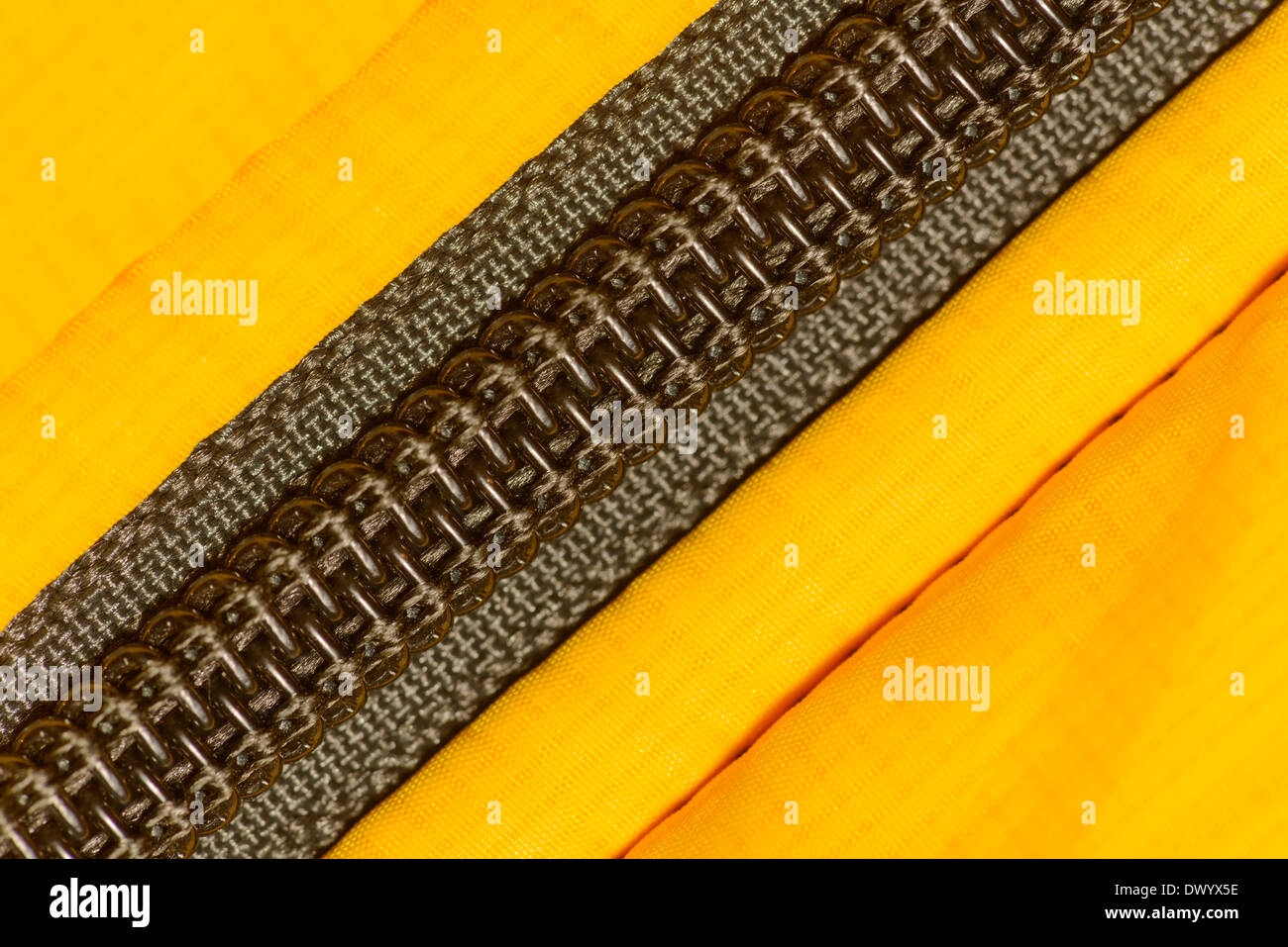 A coil zipper made of spiral plastic elements sewn into a yellow