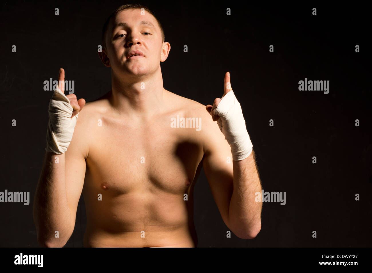 Confident young boxer gesturing his optimism with his gloved hands raising his finger in the air as he psyches himself up for a Stock Photo