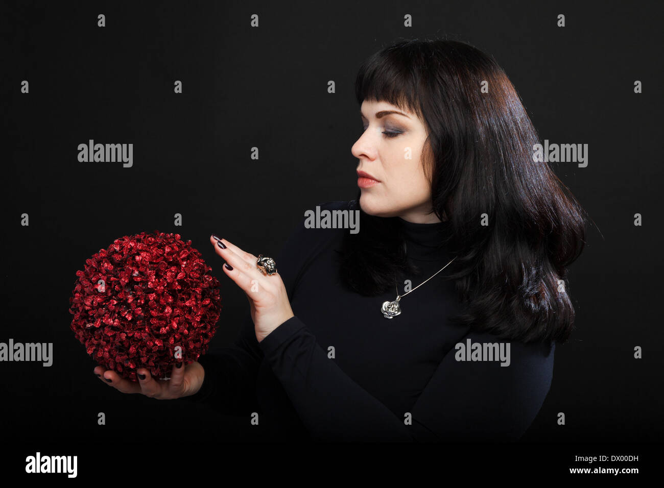 medium woman or fortune teller holds red magic ball Stock Photo