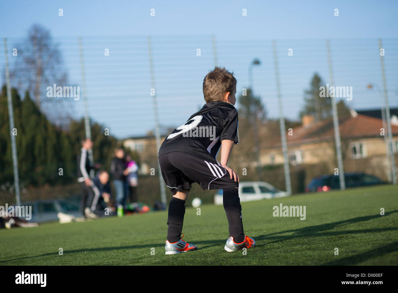 Young soccer player taking a rest during a soccer match. Trademarks have been removed. Stock Photo