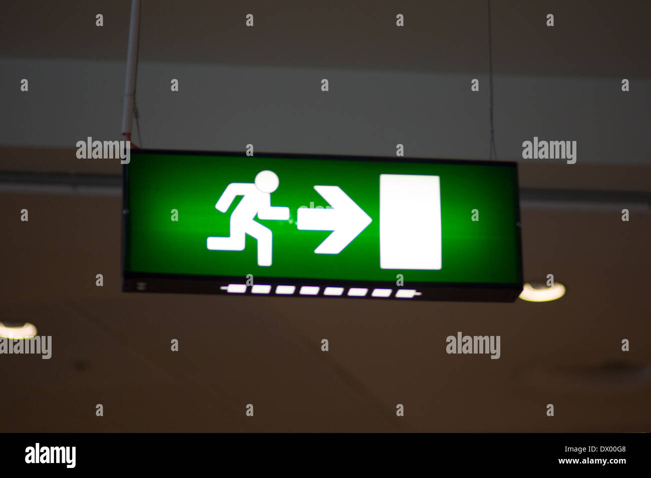 Emergency sign with white man, white arrow and white door on green background. Stock Photo