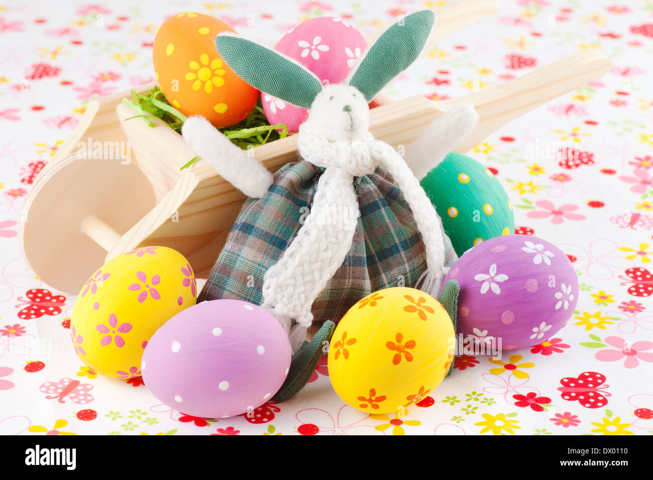 Cute Easter bunny rabbit with a little wheelbarrow and eggs Stock Photo