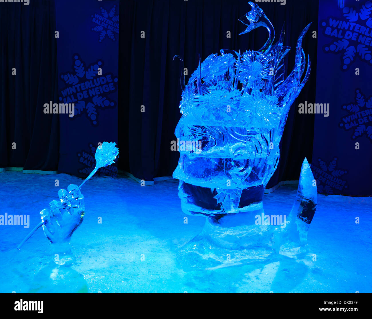 Ice sculpture of human head decorated with flowers, illuminated at night in Confederation Park, Winterlude Event, Ottawa, Canada Stock Photo