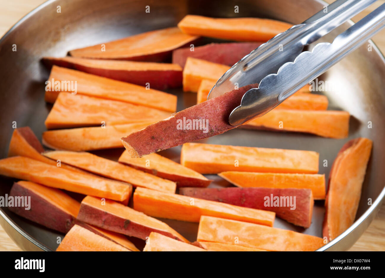 Horizontal photo of freshly cut Yams in stainless steel frying pan with