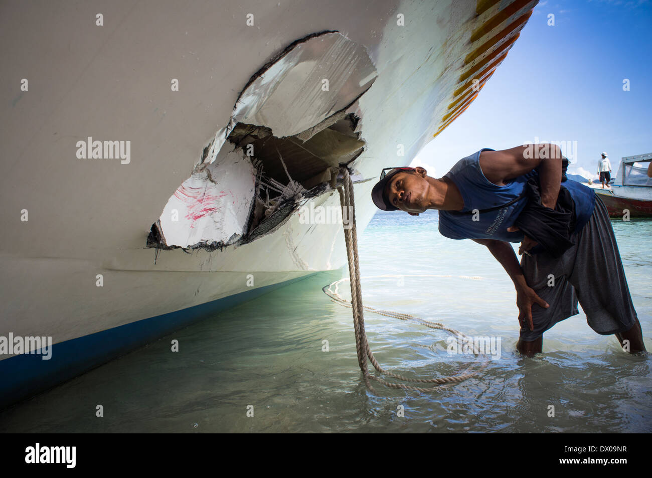 man looking at the damage to the ship, Gili islands, Trawangan, Indonesia Stock Photo