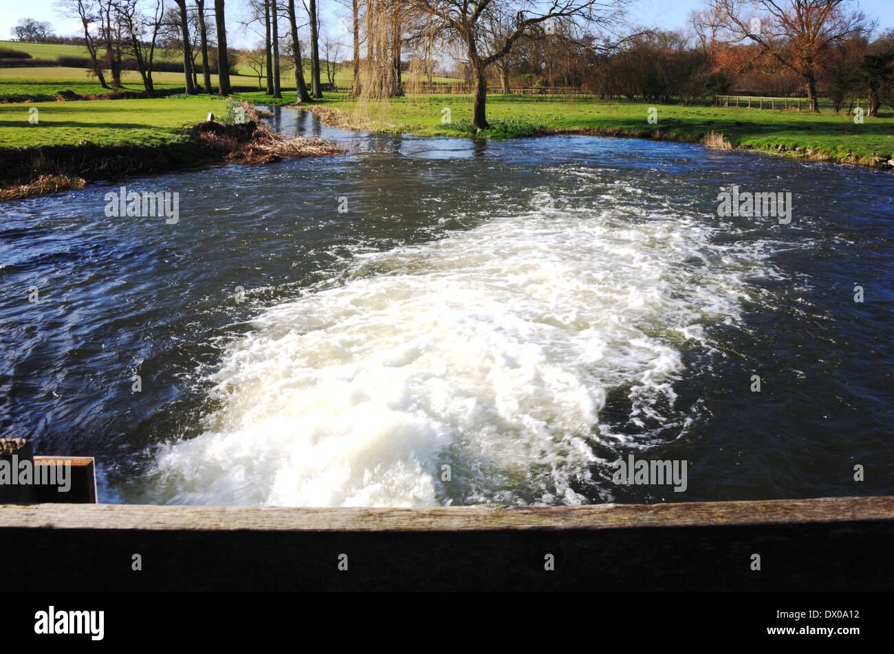 A view of turbulent water exiting Bintree Mill bypass sluice at Bintree, Norfolk, England, United Kingdom. Stock Photo