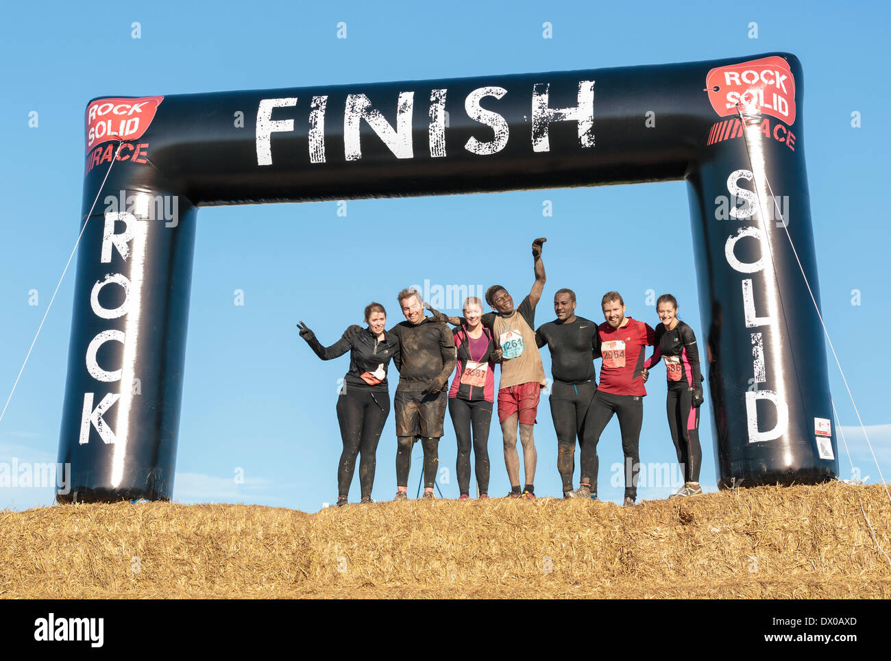 A team of friends pose for a photograph at the finish line an obstacle course at Escot Park near Exeter Devon on March 15, 2014. Over 3,500 entrants entered the event which promotes fitness and team spirit. Stock Photo