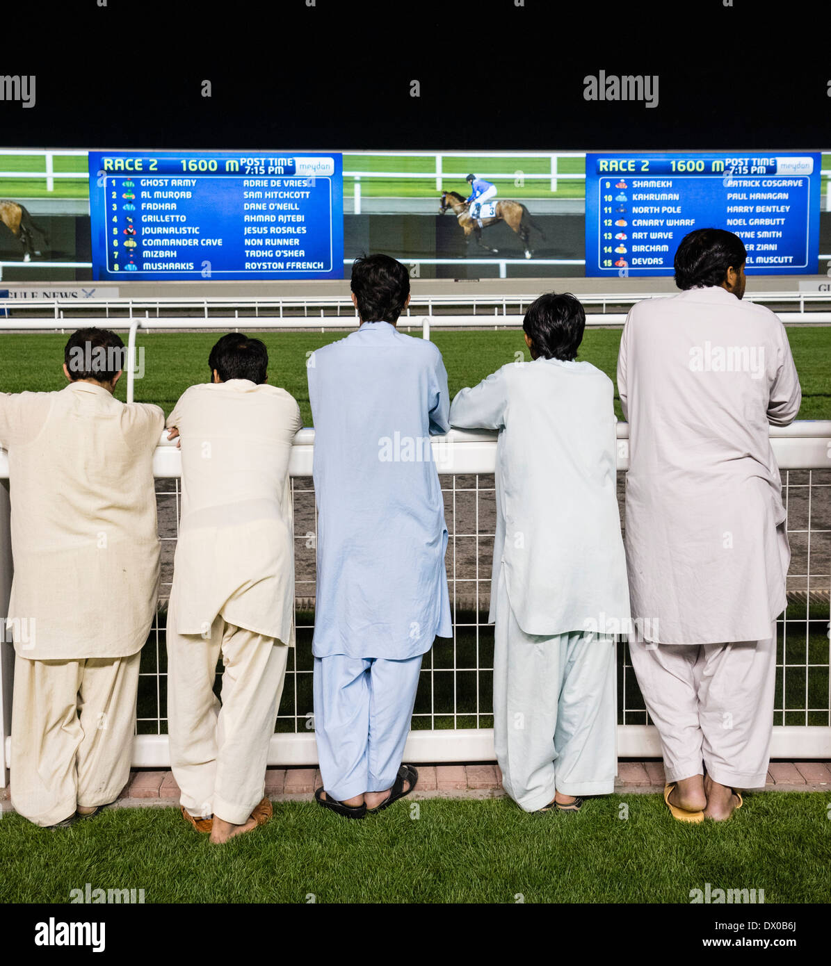 Spectators at horse racing meeting at Al Meydan racecourse at night in Dubai United Arab Emirates Stock Photo