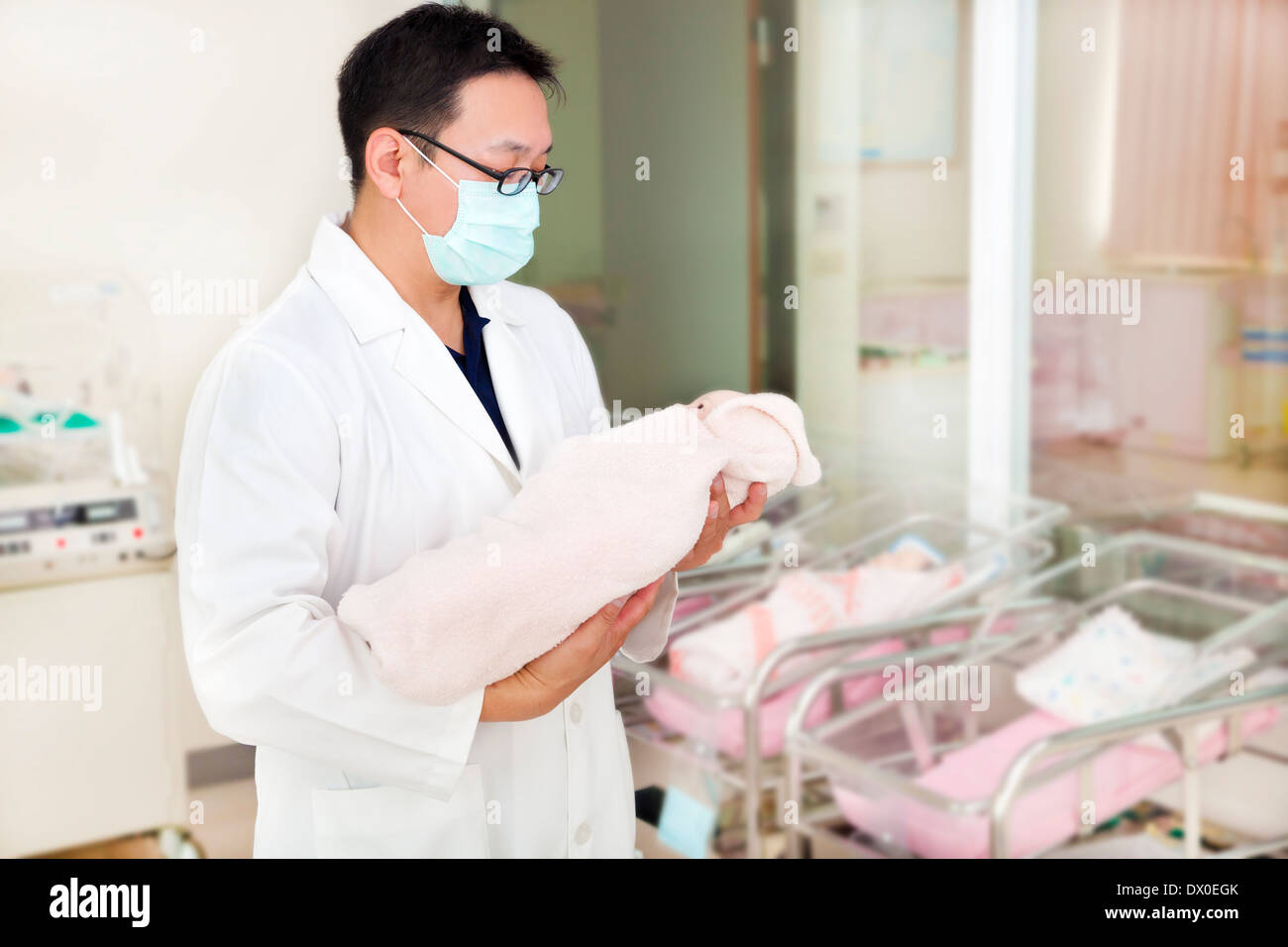 doctor holding a newborn baby in a baby room in hospital Stock Photo