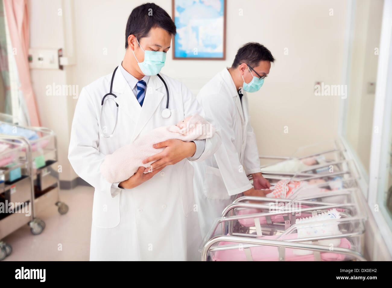 gynecologist doctor holding a fake newborn baby in hospital Stock Photo
