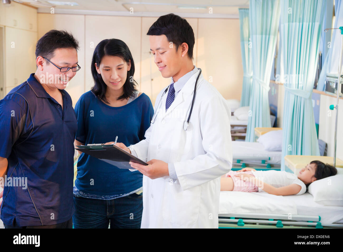 pediatrician explain kid condition to her parents in a hospital Stock Photo