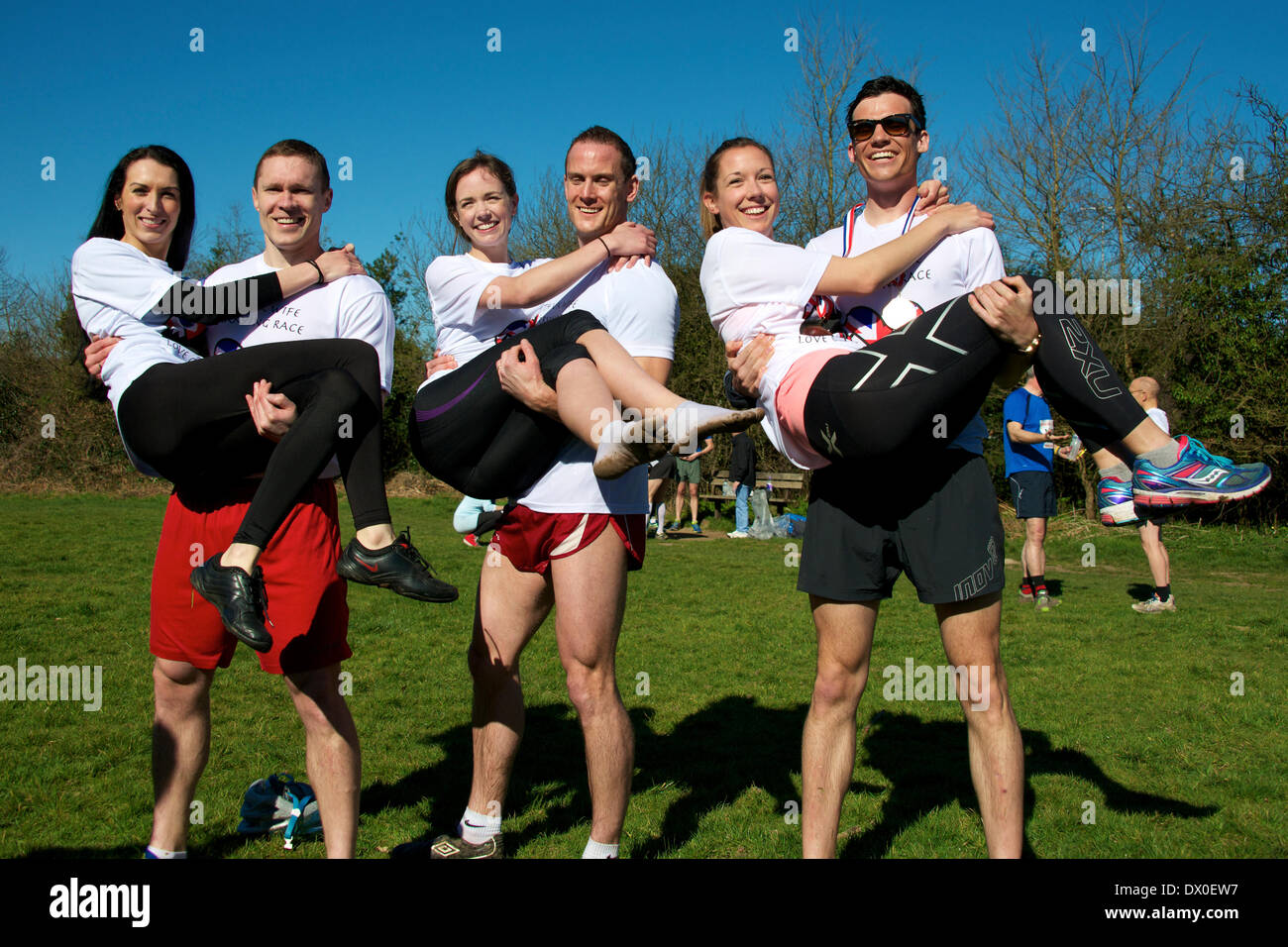 Dorking, Surrey. Sunday 16th March 2014. The 7th UK Wife Carrying Race takes place at The Nower Dorking. Image shows the three finalists with Rich Blake Smith and 55kg Anna in the middle, in second place on the left is Vytautas Kirkliauskas with 52kg wife Neringa Kirkliauskiene and third place on the right, Benjamin Hall and 61kg Gemma Taylor Credit:  Photo by Lindsay Constable/  Alamy Live News Stock Photo