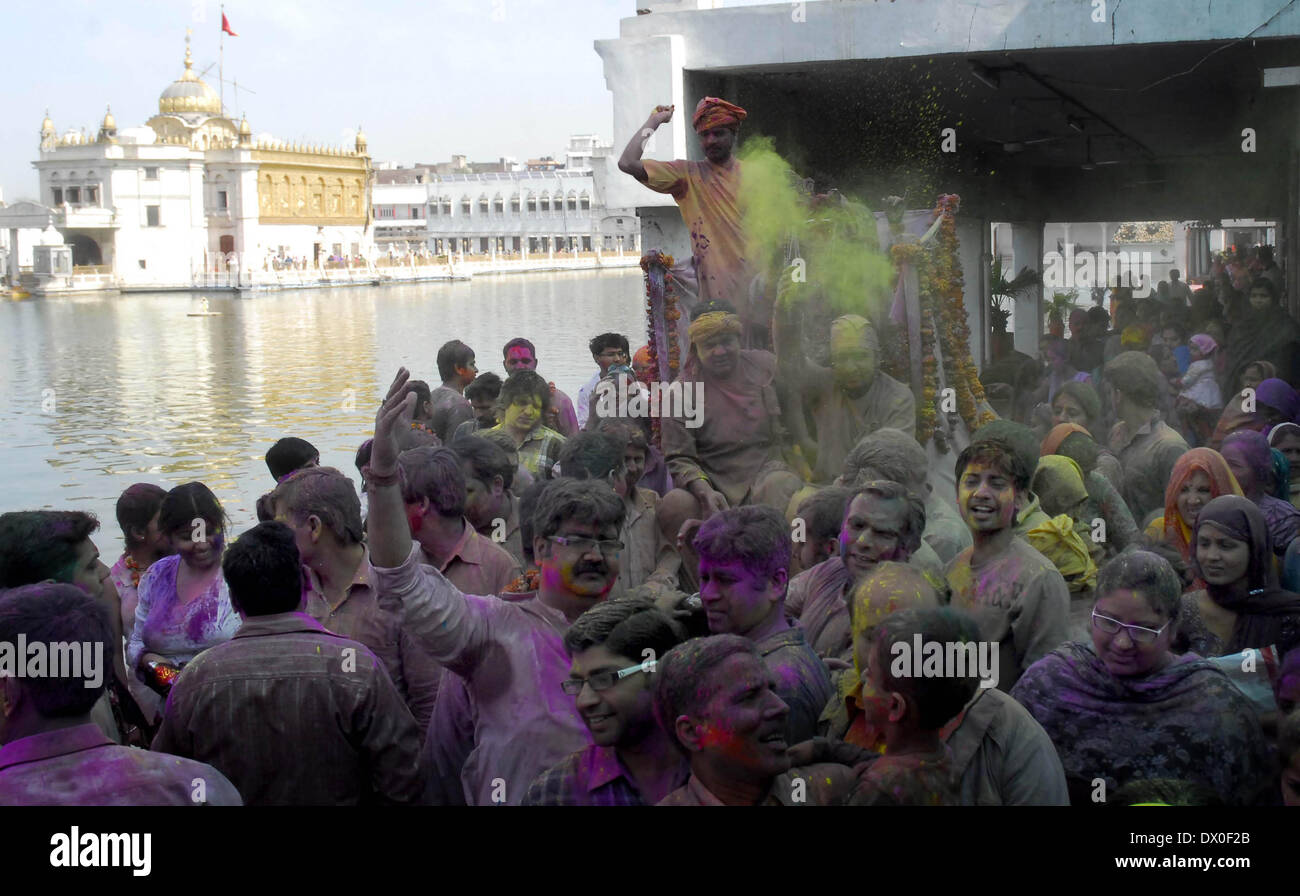 Amritsar, India. 16th March 2014 Hindu devotees play with coloured powder as celebrating Holi at Durgiana Temple in Amritsar on Sunday. Holi, the Hindu festival of colors that also marks the advent of spring, is being celebrated across the country Monday. Credit:  PACIFIC PRESS/Alamy Live News Stock Photo