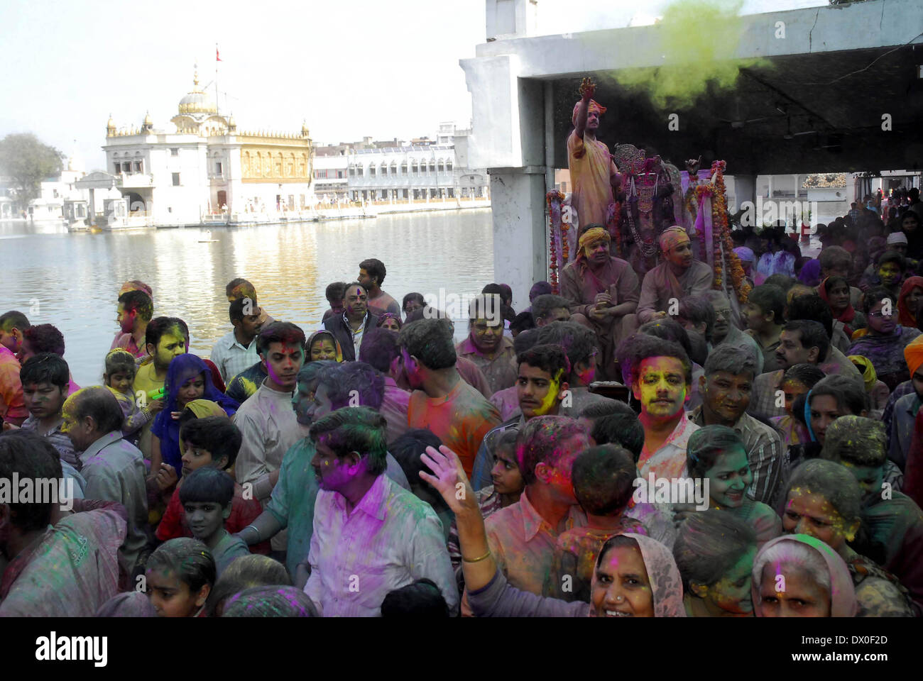 Amritsar, India. 16th March 2014. Hindu devotees play with coloured powder as celebrating Holi at Durgiana Temple in Amritsar on Sunday. Holi, the Hindu festival of colors that also marks the advent of spring, is being celebrated across the country Monday. Credit:  PACIFIC PRESS/Alamy Live News Stock Photo