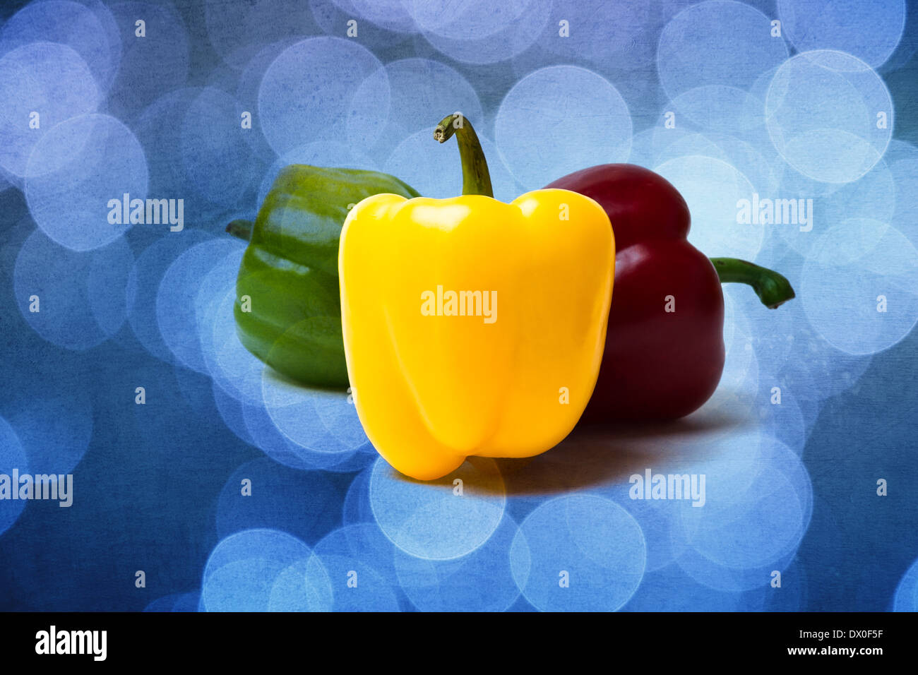 Three sweet peppers of red, yellow and green color. Yellow pepper is a