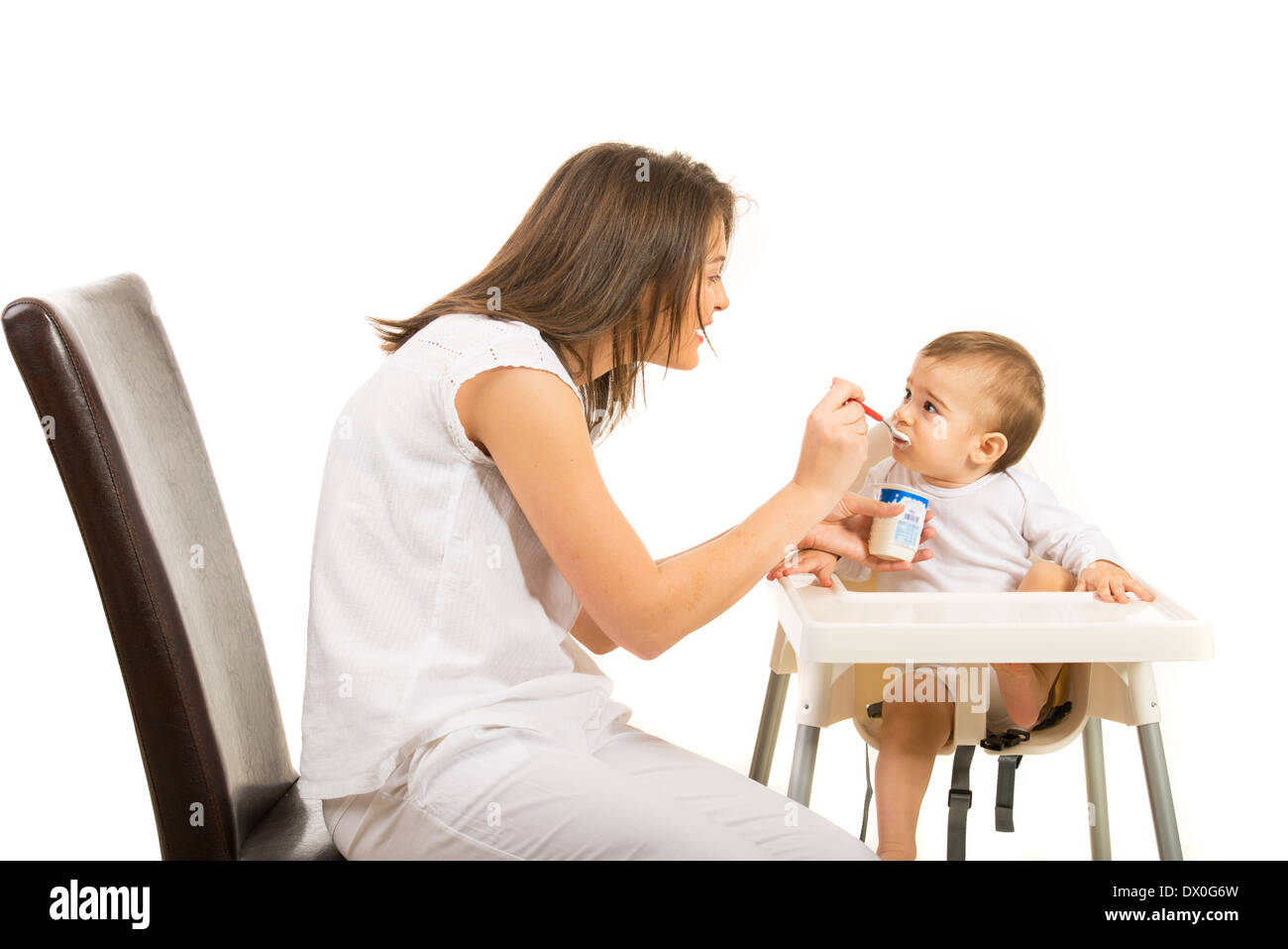 Mother gives her baby to eat yogurt isolated on white background Stock Photo Alamy
