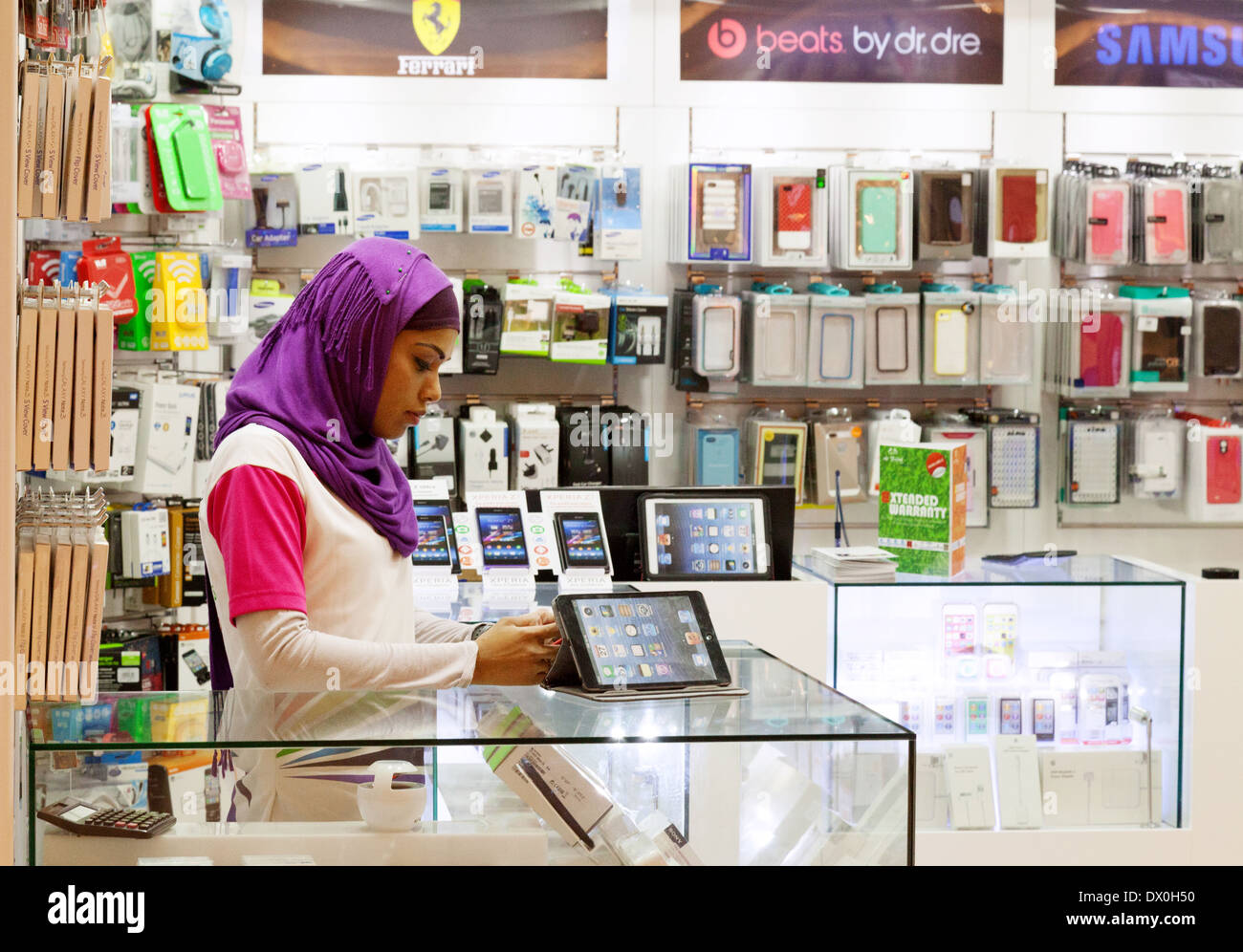 Muslim woman shop assistant at work in a technology store, Dubai Mall, Dubai, UAE, United Arab Emirates Middle East Stock Photo