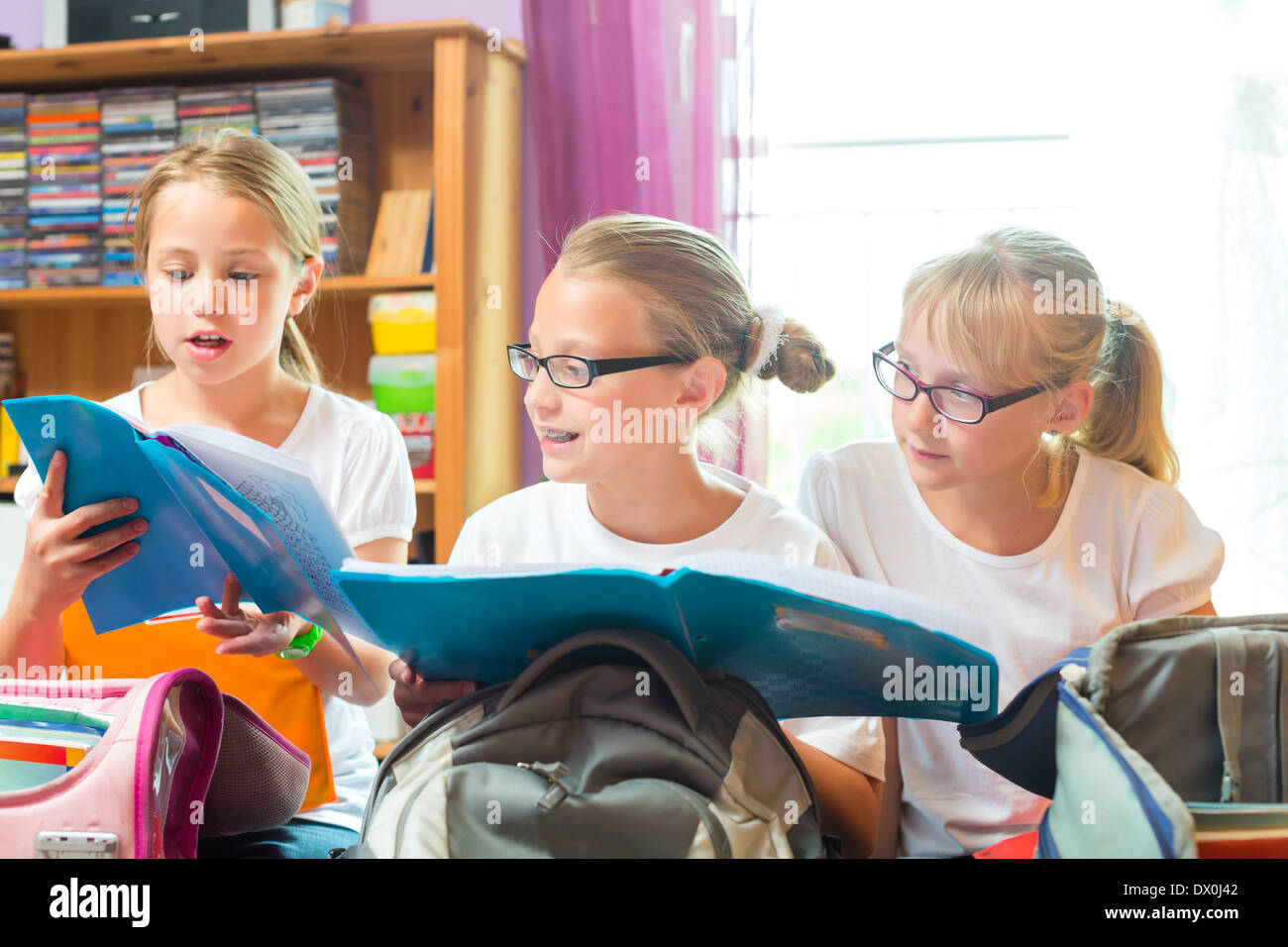 Girls or Sisters packing schoolbags with text books for school next day Stock Photo