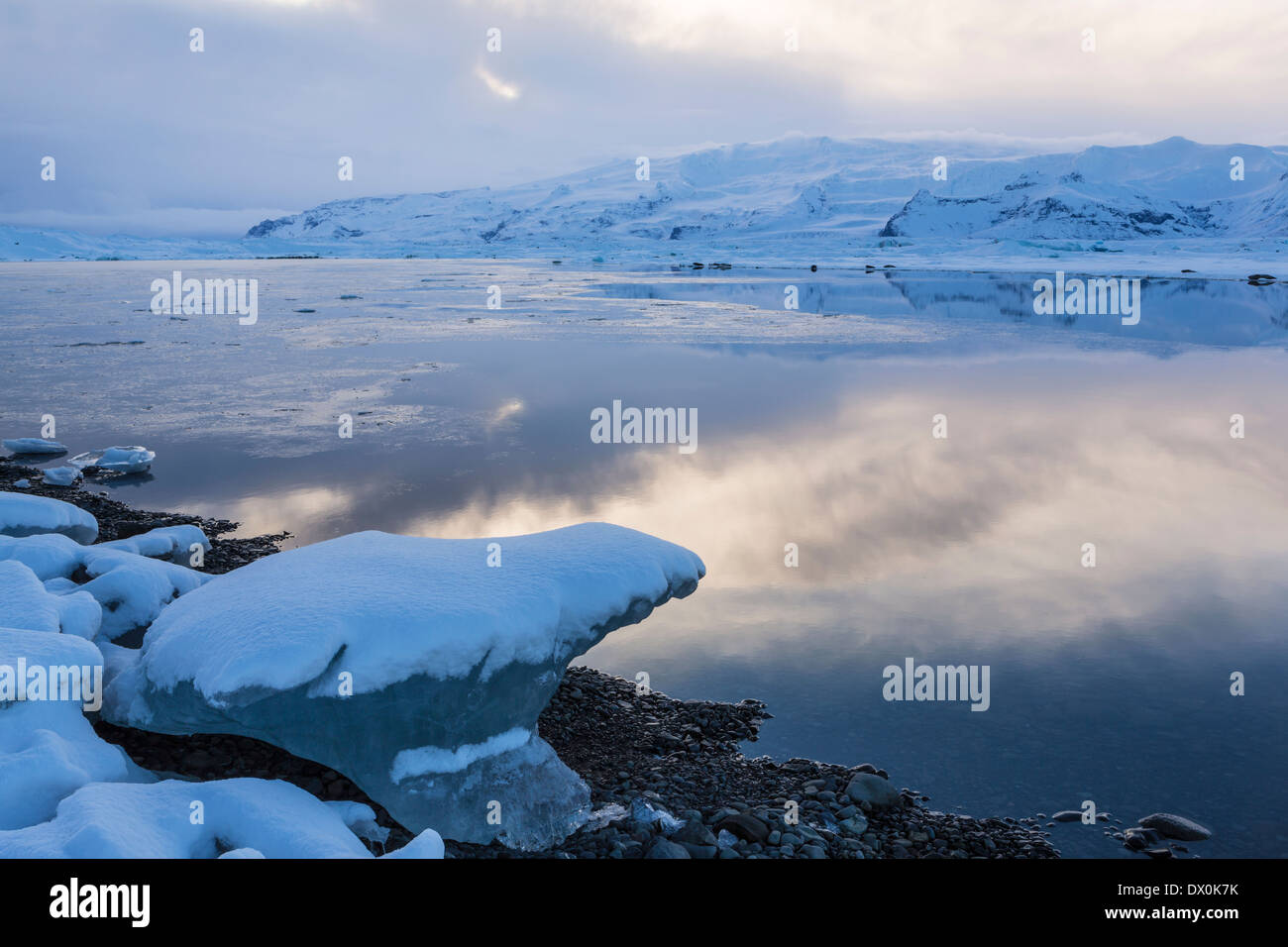 Glaciers and mountains reflected in icy Jokulsarlon glacial lagoon on a winter's evening in Iceland (HDR) Stock Photo