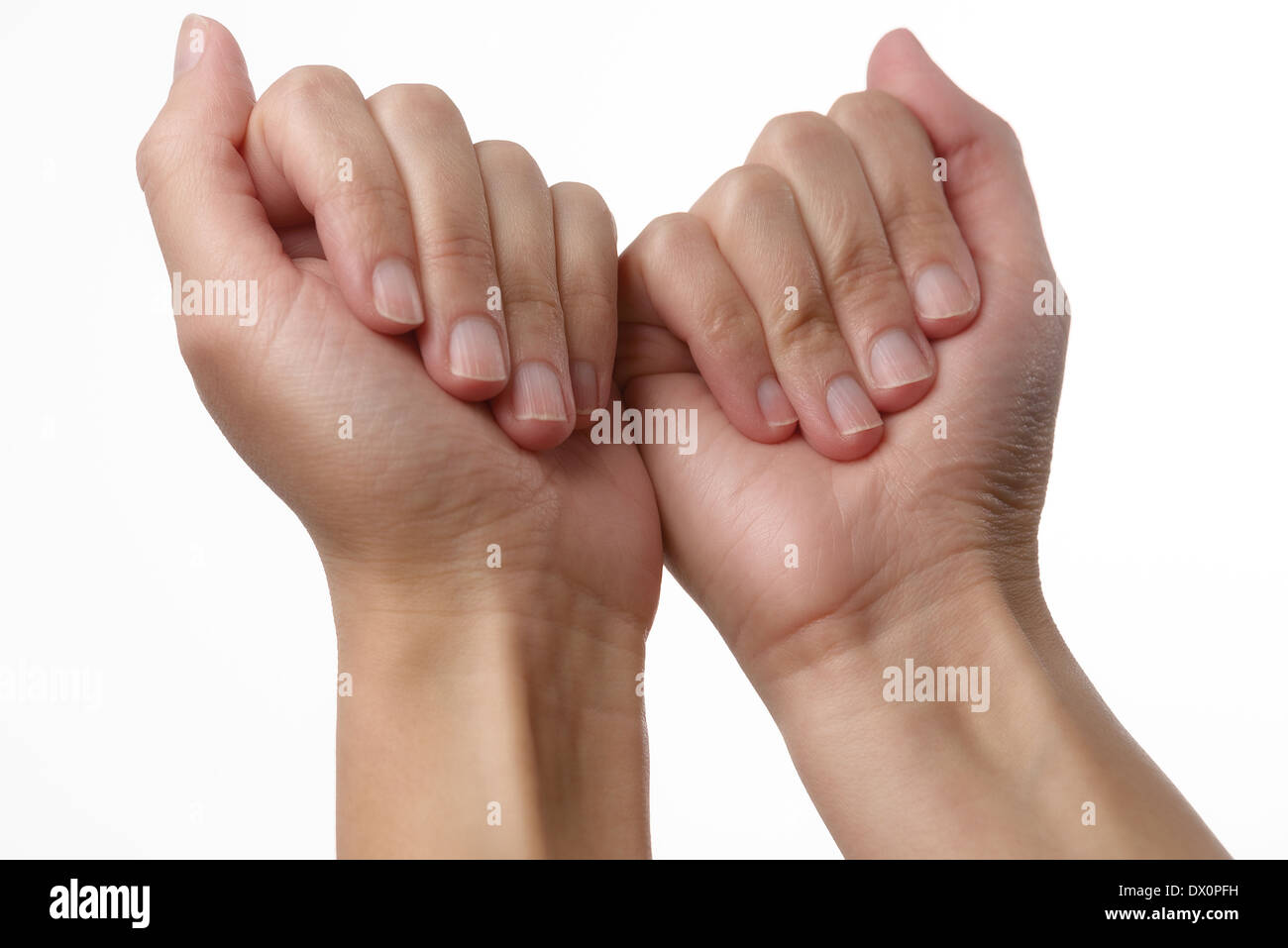 Woman with natural manicured nails displaying her fingers bent onto her palms in a skincare, nail care and beauty concept Stock Photo