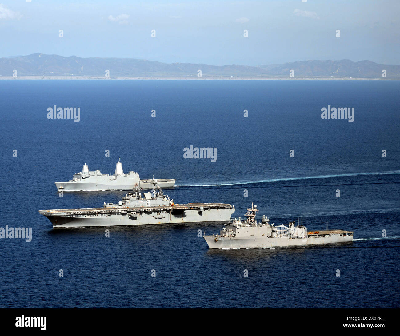 US Navy amphibious assault ship USS Makin Island alongside dock landing ship USS Comstock and amphibious transport dock ship USS San Diego during sea qualifications in preparation for its upcoming scheduled deployment March 13, 2014 in the Pacific Ocean. Stock Photo