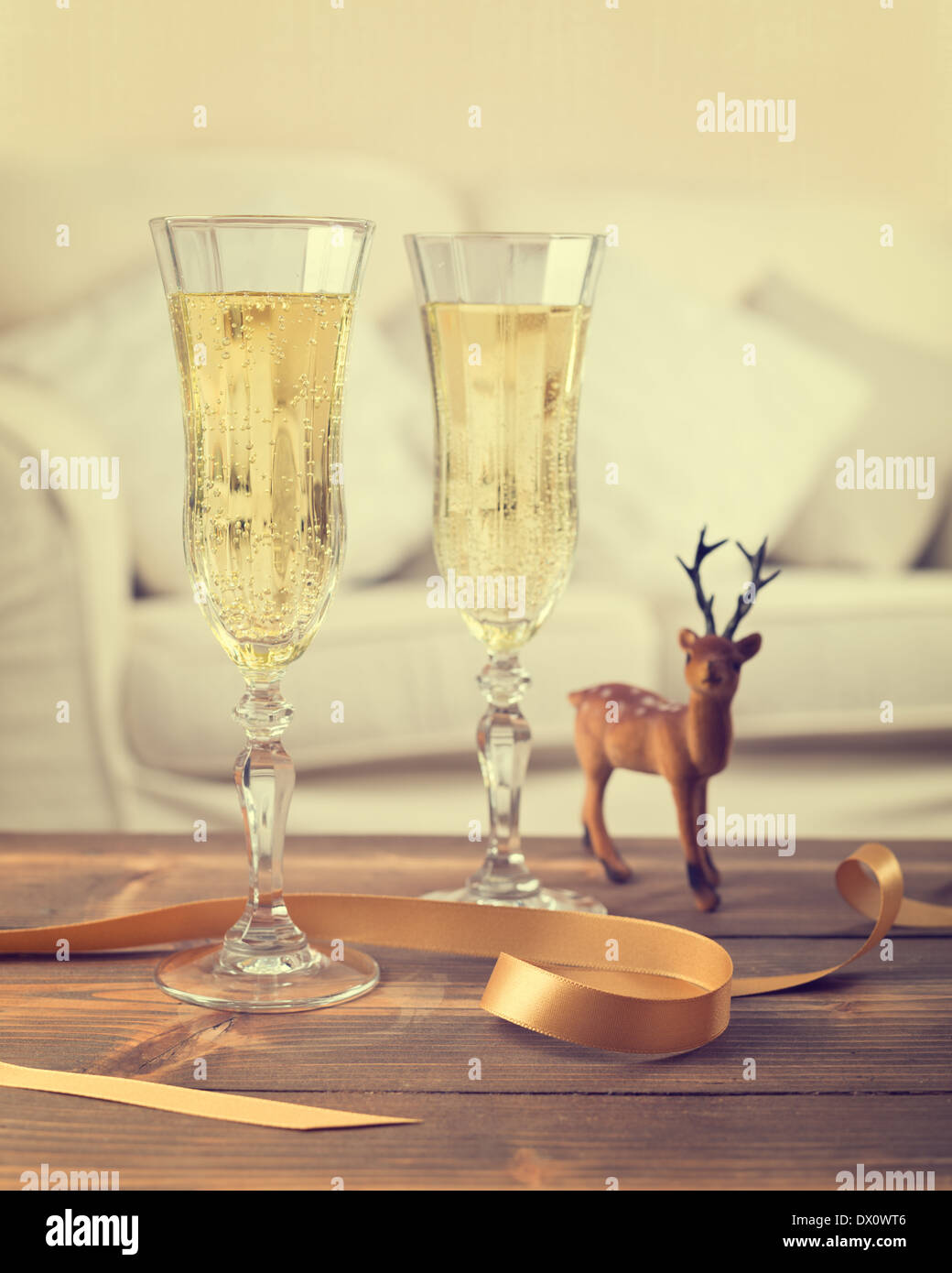 Two glasses of champagne with reindeer decoration - vintage tone effect added Stock Photo