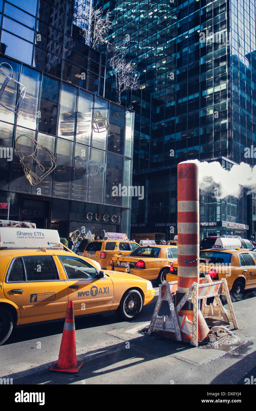 Steam pipe vent stack and yellow cab at roadworks New York City. Stock Photo